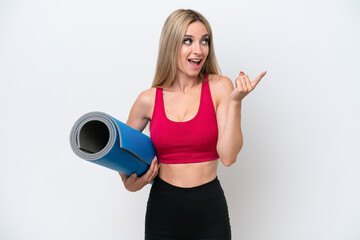 Young sport blonde woman going to yoga classes while holding a mat isolated on white background intending to realizes the solution while lifting a finger up