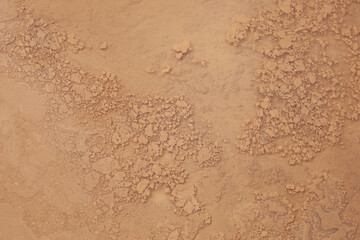 Abstract textured background wet of clay, browned liquid surface with particles