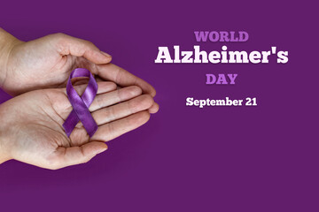 World Alzheimer's day. September 21. International Epilepsy Day. Adult hands holding purple ribbon on purple background. World Lupus Day