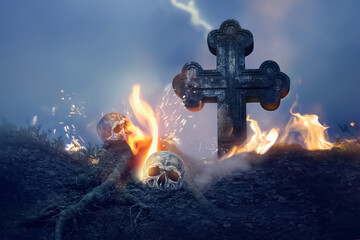 Fototapeta premium Cross and skull in the cemetery. Halloween image.