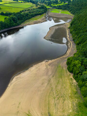 Fototapeta na wymiar Aerial drone view of the dry reservoir basin at Lindley Wood Reservoir, North Yorkshire, UK, following heatwave 2022 and hot weather leading to drought conditions in areas of the country.