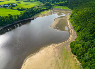 Aerial drone view of the dry reservoir basin at Lindley Wood Reservoir, North Yorkshire, UK, following heatwave 2022 and hot weather leading to drought conditions in areas of the country. - obrazy, fototapety, plakaty