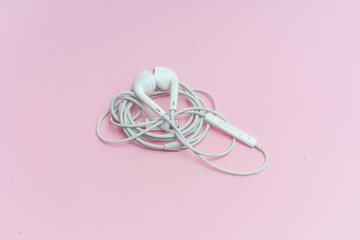 Audífonos blancos sobre fondo rosa.