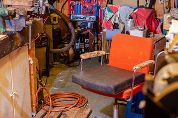 Orange chair in old, messy work shop