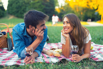 Young smiling couple having picnic on the sunny summer meadow