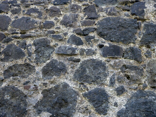 Remains of an old castle. Ancient fortifications made of stone. Museum in the open air. Wall of a medieval castle. Background from ancient stonework.