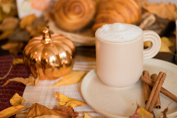 Obraz na płótnie Canvas Capuccino in fall setup with croissants on the background