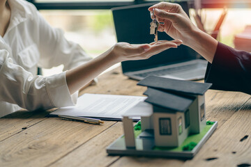 Obraz premium Real estate agents provide keys to customers after signing a contract, renting or buying a home with home loan and home insurance offers.