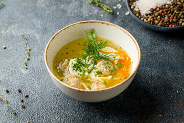 Chicken soup bouillon in a plate with chicken meatballs