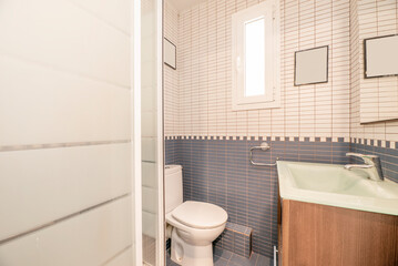 Bathroom with glass sink on wooden cabinet, frameless mirror and shower cabin