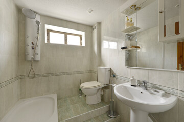 Bathroom with porcelain sink, thin white metal framed mirror and tiled walls
