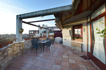 Penthouse bay window with tile floors and glass dining table with green metal chairs