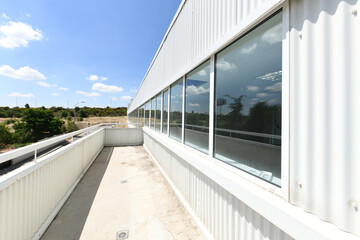 Viewpoint terrace of an industrial warehouse with a large window along the entire length of the...