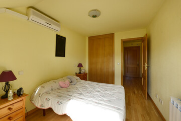 Bedroom with double bed, children's cushions on the pillow and wardrobe with oak doors