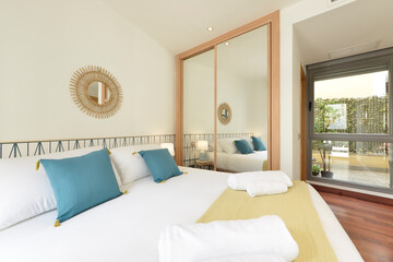 Bedroom with contemporary decoration with built-in wardrobe with sliding mirror doors and wooden...