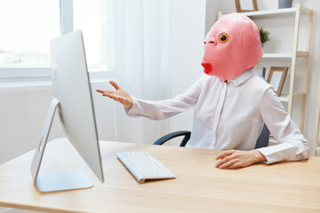 Angry businesswoman in pink fish mask screaming to desktop Raging after computer software crash error at workplace in modern office. Crazy director work online in financial corporation. Copy space - Powered by Adobe