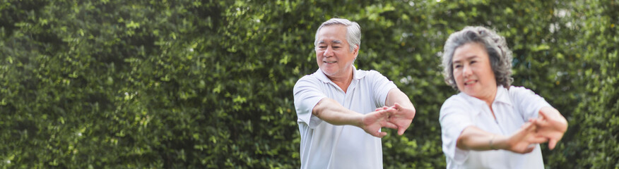 Chinese Senior adult man and woman stretching hands and arms before exercise at park. Happy elderly couple enjoying workout at outdoor