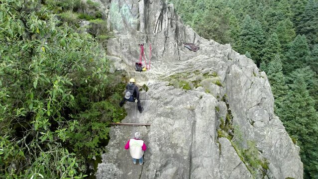 drone shot of a climber descending the mountain being guided by an expert athlete