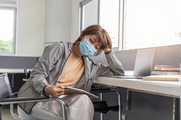 Beautiful woman wearing a face mask read book in library.