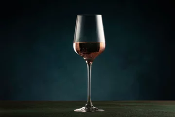 Fotobehang Rose wine from the zinfandel variety in wine glass on dark background, copy space © 5ph