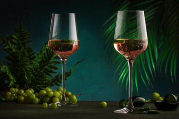 Rose pink wine with jalapeno pepper in wine glass, dark background, copy space