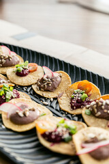 Vegan tapas, served on a black leaf-shaped platter