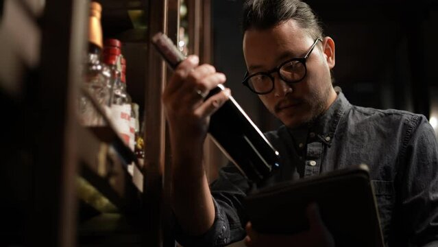 Night club concept of 4k Resolution. The bartender is checking the merchandise in the store. A group of specialized clubs that sell alcoholic beverages.