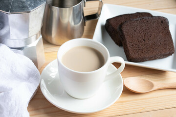 Hot coffee latte in a white coffee mug with cake.Breakfast