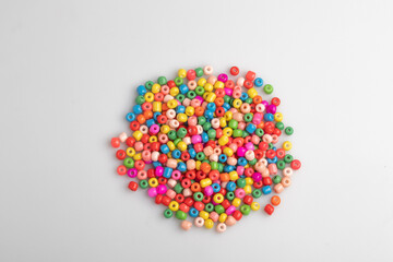 Assorted colored plastic beads on a white background.