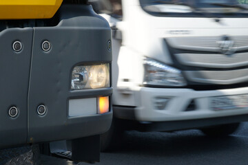 The headlight of a car with a turn signal on against the background of a moving car.
