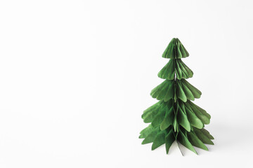 Handmade foldable Christmas tree from plastic free material - green paper isolated on white background. DIY concept.