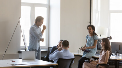 Smiling multi racial teammates attend briefing, take part corporate seminar lead by Hispanic male...