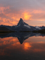 Sunset with dramatic alpenglow at the high mountain lake Stelisee with the famous Alps peak...