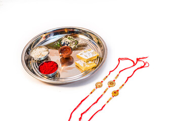 A plate or thali with rice grain and sweets on the occasion of Indian festival