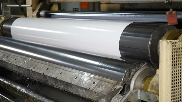 Paper production machine. Processing of secondary resources. Paper recycling. Part of technological proccess in large factory. Paper being impregnated with formalin for furniture production. 4 k video