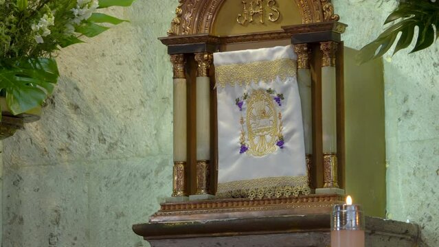 Sagrario con mantel y vela encendida de cera dentro de iglesia catolica parroquia religi&oacute;n arte