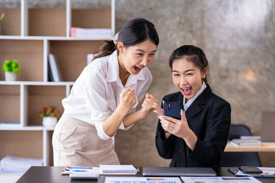 Team work process Two women are immensely delighted, Yes, having succeeded with a smartphone in an open office. business idea Data Analysis, Roadmap, Marketing, Accounting, Auditing