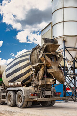 Concrete mixer truck in front of a concrete batching plant, cement factory. Loading concrete mixer...