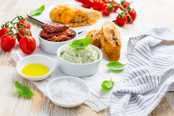 Avocado spread and sun dried tomatoes with olive oil as antipasto and baguette