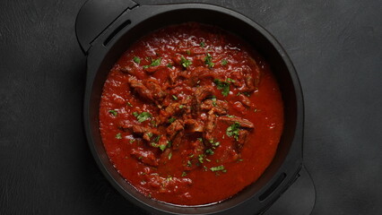 Beef stew with tomato sauce, spices and herbs in a pan