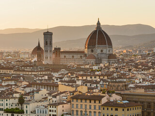Obraz premium Gothic Florence's cathedral, the Duomo, named in honor of Santa Maria del Fiore, Italy, Tuscany turns off above the roofs of nearby houses, at summer sunset