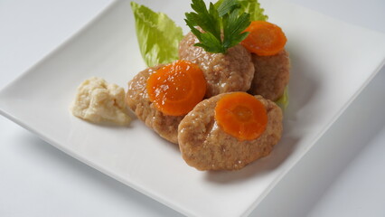 Traditional Jewish Passover food gefilte fish with carrots, horseradish, and lettuce