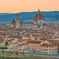 Fototapeta na wymiar Gothic Florence's cathedral, the Duomo, named in honor of Santa Maria del Fiore, Italy, Tuscany turns off above the roofs of nearby houses, at summer sunset