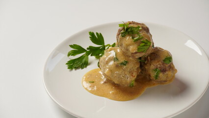 A plate of Swedish meatballs in cream sauce with mashed potato.