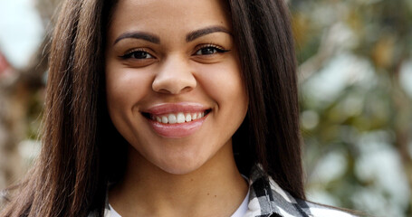 Fototapeta premium Close up portrait beautiful young black woman smiling outdoor.