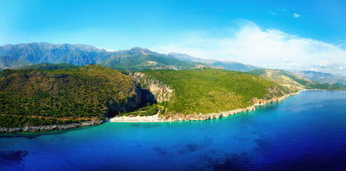 Gjipe Beach. Panoramic, aerial  view from the sea side. Clear waters of the Ionian Sea, a clean pebble beach, impressive canyon and mountains in background. The best beach in Albania.