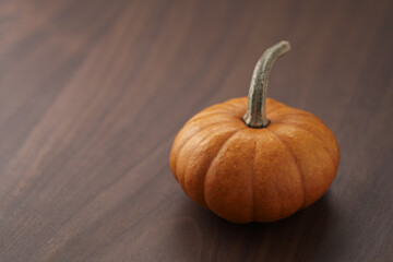 Cute orange pumpkin on wood table with copy space