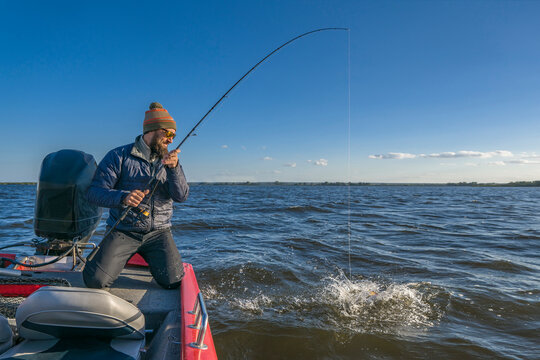 Boat fishing. Fisherman catch big fish with splash in water