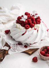 sweet dessert Pavlova cake with raspberries and cream peach