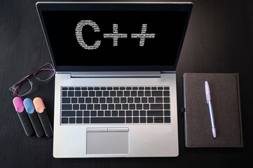 Laptop with C++ text. Top view. C plus plus inscription on laptop screen. - obrazy, fototapety, plakaty